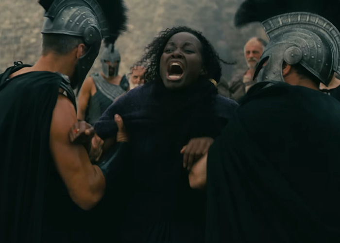 A dramatic scene from Odyssey where Lupita Nyongo's character is restrained, sparking a woke question for Homer.