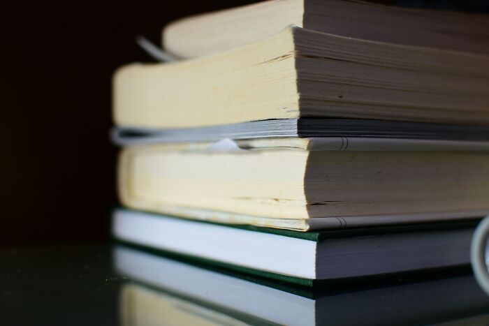 A stack of books on a dark background, representing accumulated knowledge in contrast to infuriating mansplaining examples.