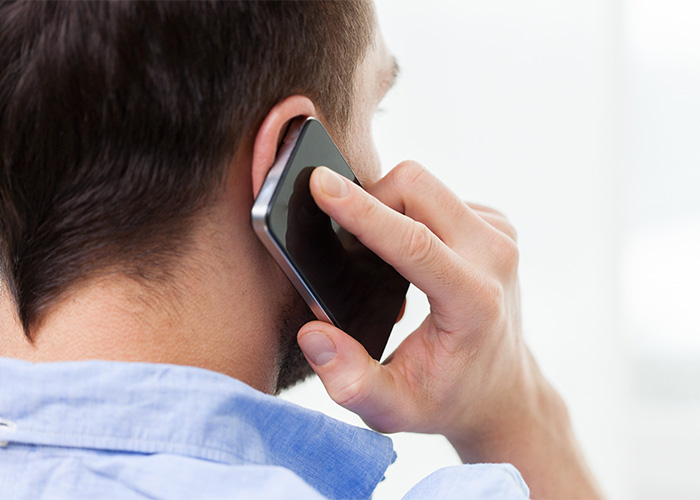 A man on the phone, a victim of a doxxing and swatting prank, communicating after the incident. A man on the phone, a victim of a doxxing and swatting prank, communicating after the incident.