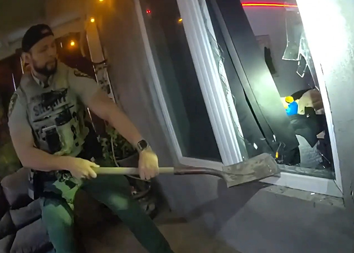 Police officer breaking a window, highlighting the severe consequences of a swatting prank gone wrong. Police officer breaking a window, highlighting the severe consequences of a swatting prank gone wrong.