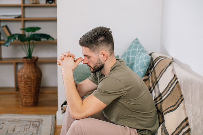 A man looking stressed, with his hands clasped, after losing more than he bargained for by an entitled act.