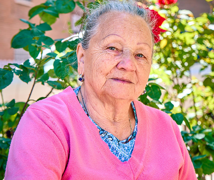 Portrait of an older woman in a pink cardigan, representing the entitled man's grandmother in the story.
