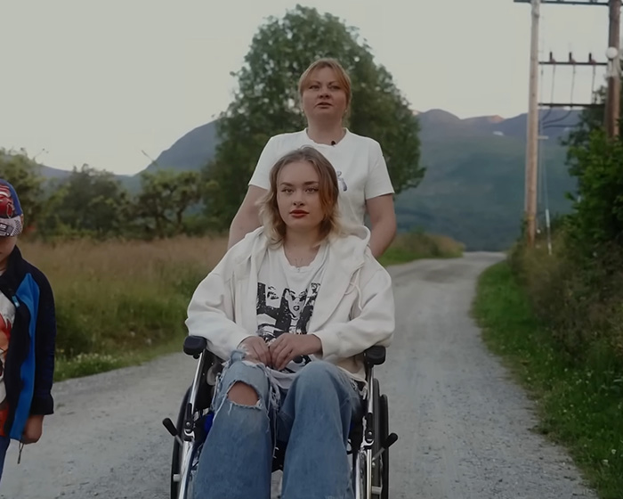 A young woman in a wheelchair, pushed by another woman, on a rural road. The model faces a fight for life. A young woman in a wheelchair, pushed by another woman, on a rural road. The model faces a fight for life.