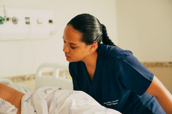 A nurse attends to a patient in a hospital bed, underscoring the importance of preventing medical mistakes.