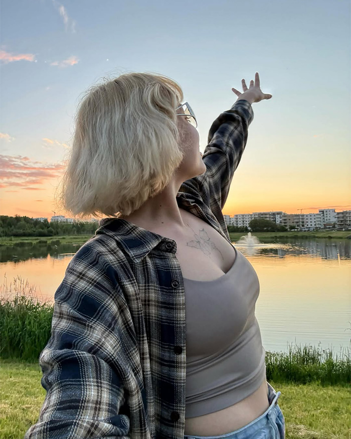 A young woman, a famous model, reaching out towards a sunset over a lake. A young woman, a famous model, reaching out towards a sunset over a lake.