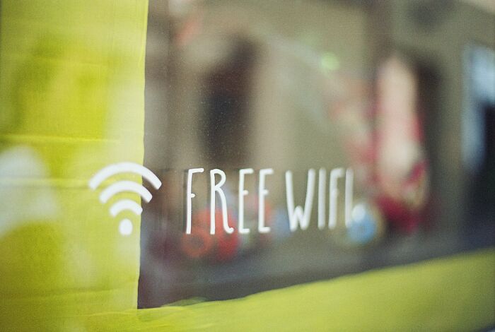 A Free WiFi sign on a glass window, revealing industry secrets of connectivity and convenience for jobs.