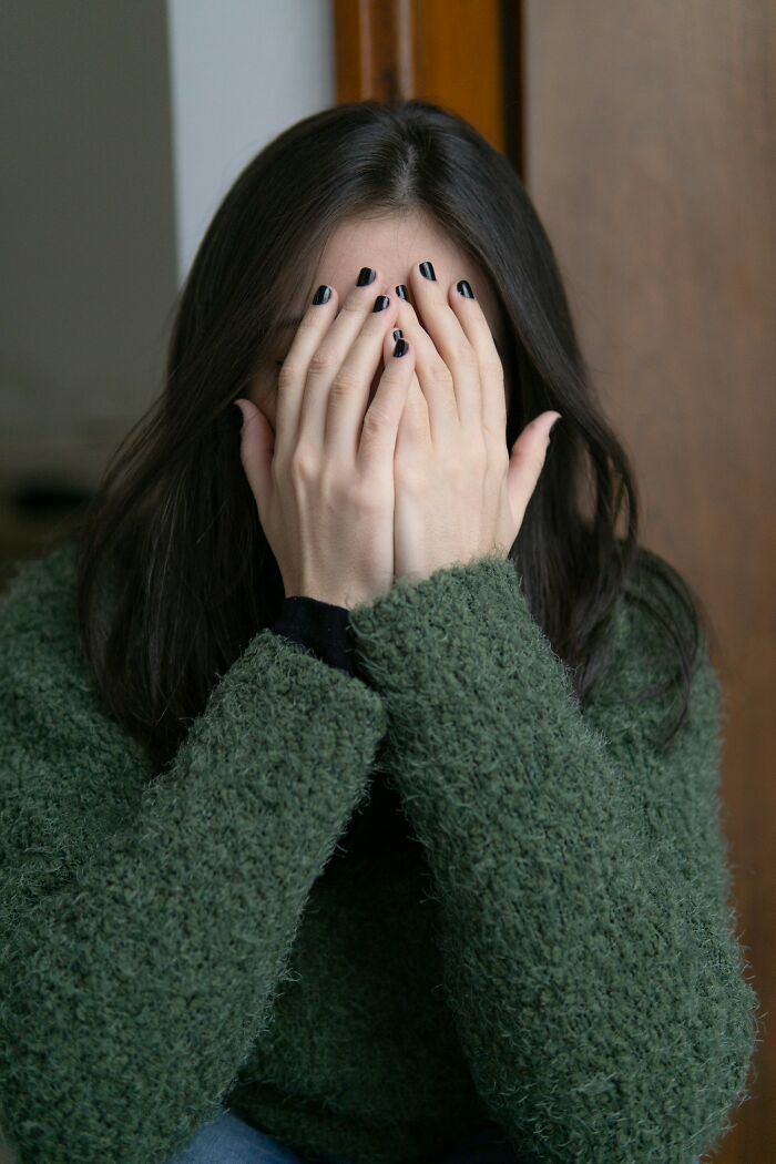 A woman covering her face with her hands, expressing an instinct to get away from deeply evil creeps.