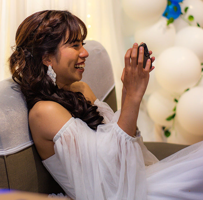 A happy bride laughing while holding a small gift. This image contrasts with the idea of wedding red flags.