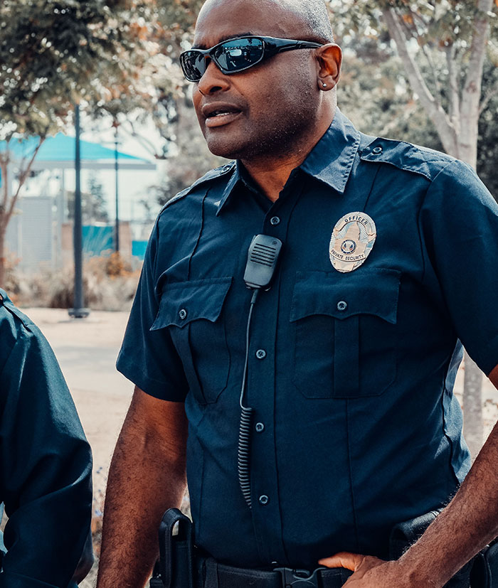A security officer wearing sunglasses and a dark blue uniform, with a microphone clipped to his shirt. This image highlights a potential wedding red flag, symbolizing issues that could lead to a short marriage.