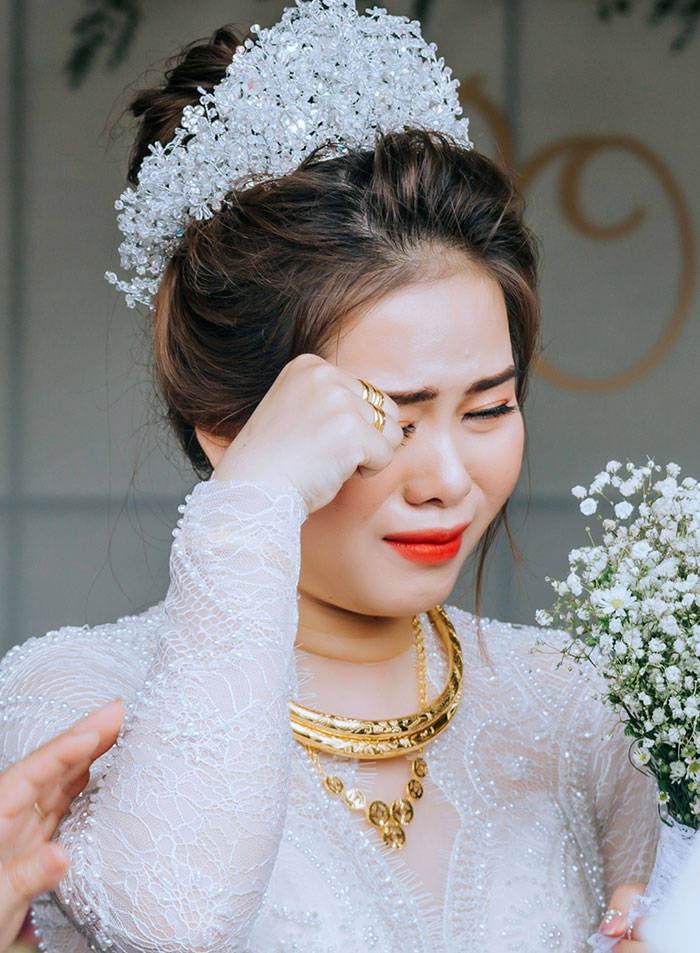A bride crying while holding a bouquet, representing marriage red flags and emotional moments.