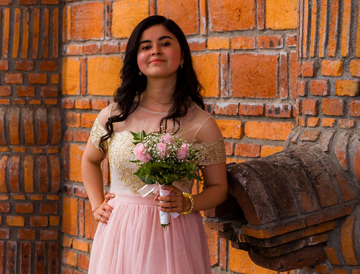 A woman in a peach dress holds a bouquet of flowers, embodying the initial joy before wedding red flags appeared.
