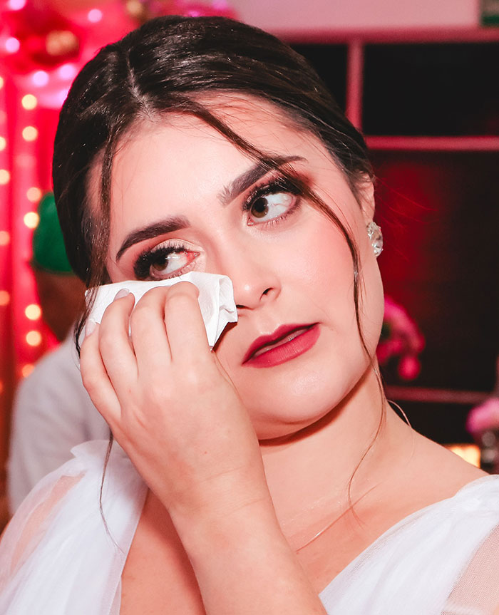 A bride wipes a tear, an emotional moment that could be related to wedding red flags or marriage stress.
