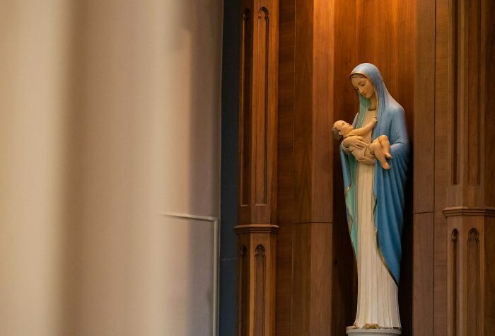 A statue of the Virgin Mary holding baby Jesus, symbolizing historical myths and religious narratives.