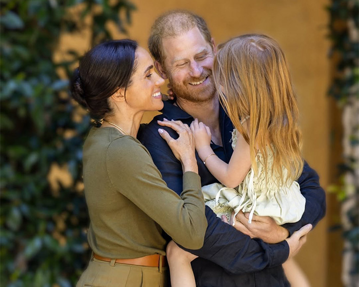 A Hollywood star embraces a child, with another Hollywood star smiling and looking at the child. A Hollywood star embraces a child, with another Hollywood star smiling and looking at the child.