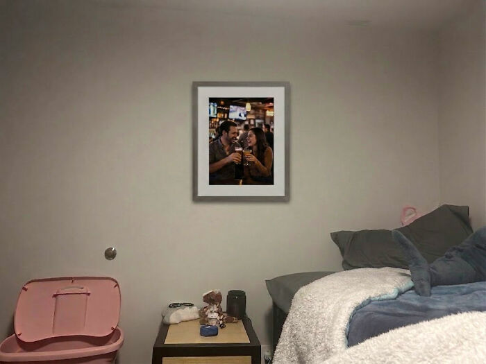 A framed photo of a couple toasting drinks, freaked out a man hanging on a bedroom wall in a woman's home.