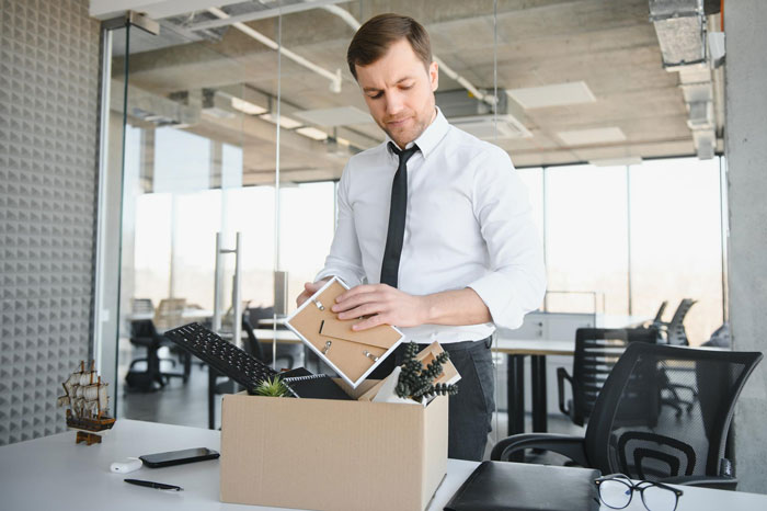 An ex-Meta worker packing a box with personal items, leaving an office after AI replaced his job. An ex-Meta worker packing a box with personal items, leaving an office after AI replaced his job.