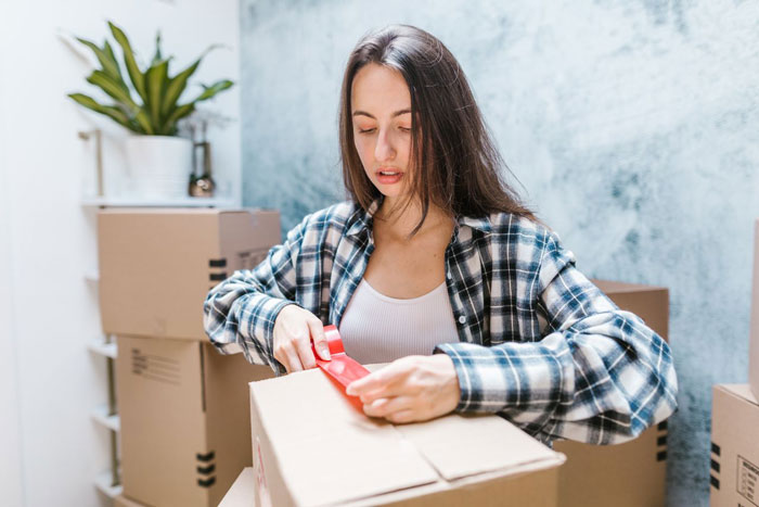 A woman packing boxes, considering her future mother-in-law's actions and her son marrying her.
