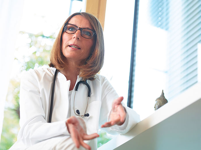 A female doctor with glasses and a stethoscope, gesturing as she discusses a teen's decision to not donate his lung to his mom. A female doctor with glasses and a stethoscope, gesturing as she discusses a teen's decision to not donate his lung to his mom.