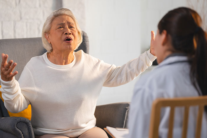 An elderly mom gestures dramatically, expressing her distress to a doctor after her teen refuses to donate his lung. An elderly mom gestures dramatically, expressing her distress to a doctor after her teen refuses to donate his lung.