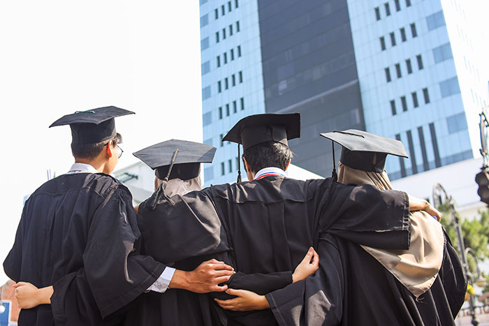 Graduating teens stand together, looking towards a building, reflecting a teen's life becoming a mess. Graduating teens stand together, looking towards a building, reflecting a teen's life becoming a mess.