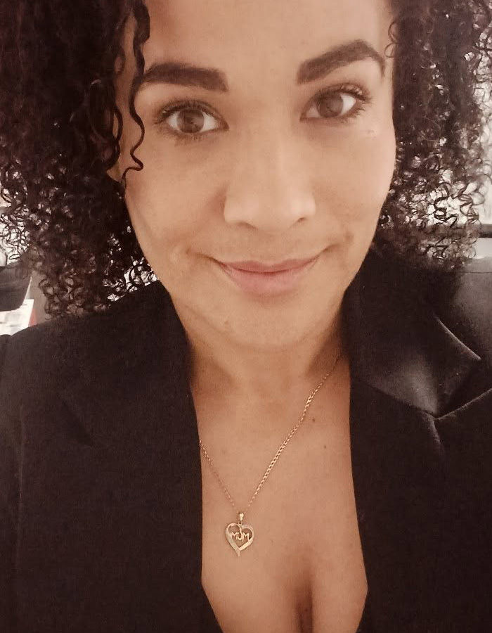 A woman with curly hair wearing a gold MOM necklace, related to a marshmallow accident.
