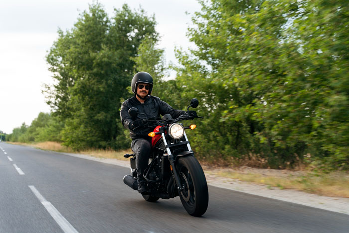 Man riding a motorcycle, showcasing one of the 5 things a mortician advises against.