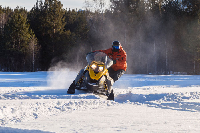 Person on a snowmobile, symbolizing one of the 5 things a mortician never wants to do.
