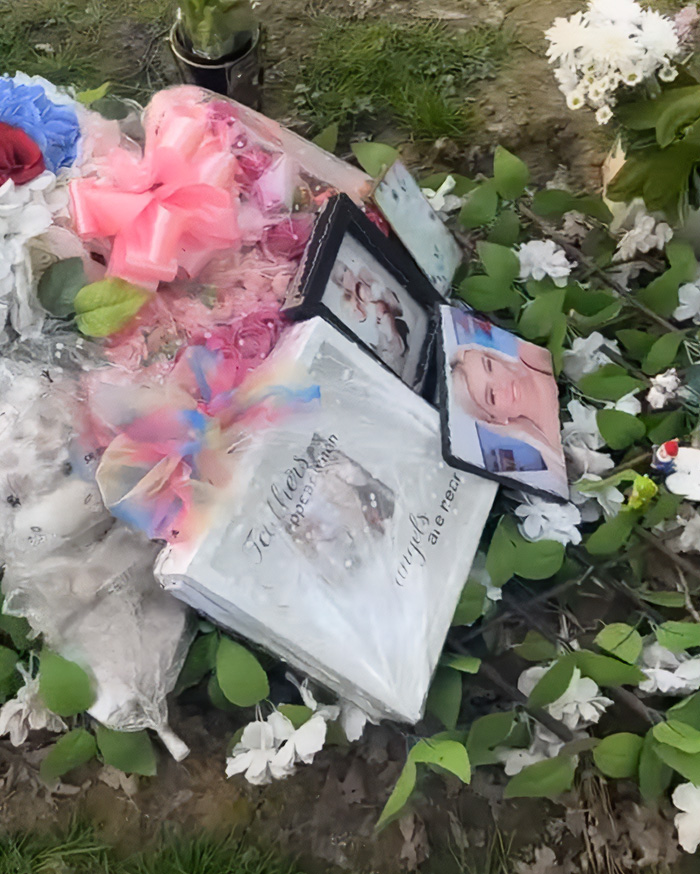 A graveside covered in flowers and photographs, mourning a mother who passed away after a botched surgery. A graveside covered in flowers and photographs, mourning a mother who passed away after a botched surgery.