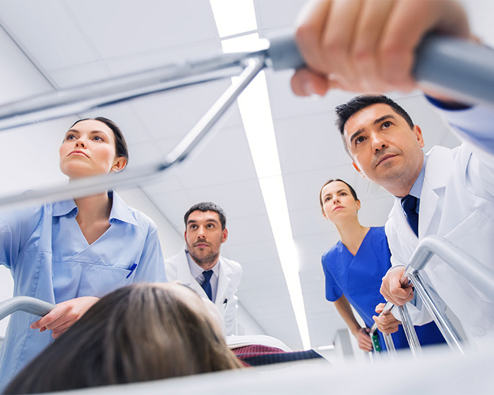 Medical staff push a woman on a gurney through a hospital, highlighting the risks of botched surgery. Medical staff push a woman on a gurney through a hospital, highlighting the risks of botched surgery.
