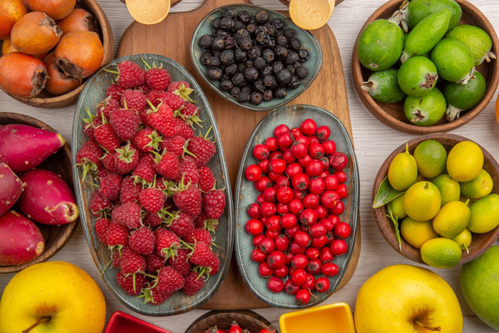 An overhead view of a vibrant assortment of fresh fruits, not including sushi, that a picky eater might avoid. An overhead view of a vibrant assortment of fresh fruits, not including sushi, that a picky eater might avoid.