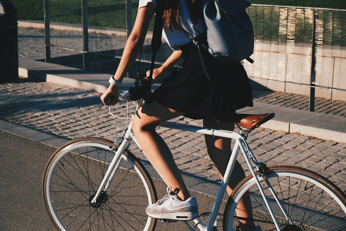 A person riding a bicycle on a paved path, a simple public moment contrasting disturbing events.