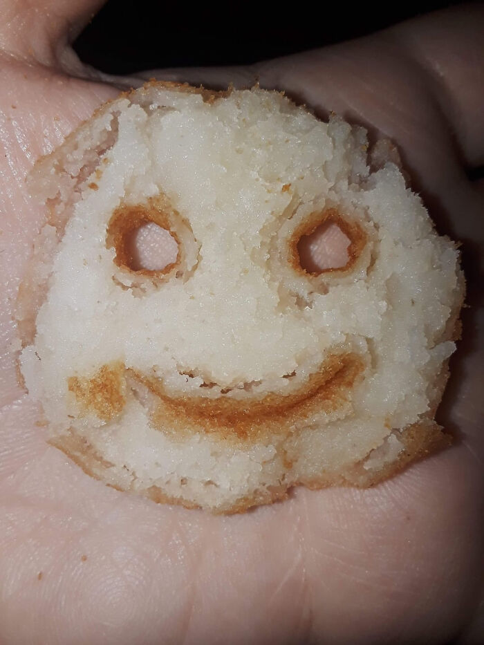 A burnt smiley-face cookie in a hand, representing a moment parents were terrified of their own children.