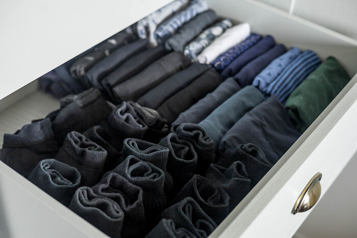 A drawer neatly organized with folded clothes, symbolizing good house etiquette.
