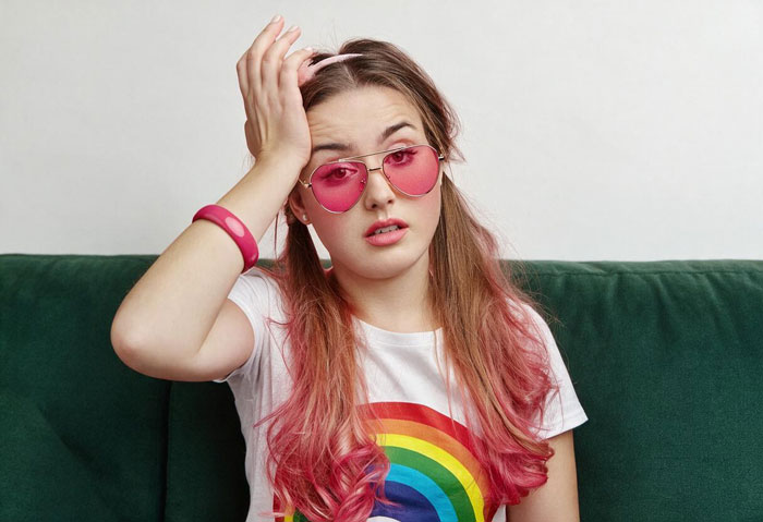 A woman with pink hair and rainbow shirt looking confused, illustrating challenges related to being nebulasexual LGBT. A woman with pink hair and rainbow shirt looking confused, illustrating challenges related to being nebulasexual LGBT.