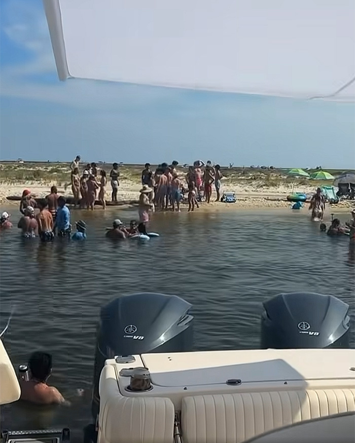 A group of people on a beach and in the water, from videos related to Nolan Wells' last moments. A group of people on a beach and in the water, from videos related to Nolan Wells' last moments.