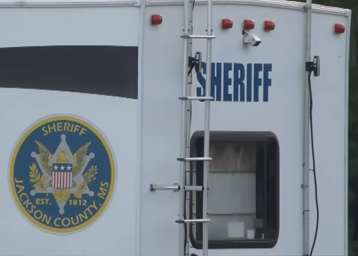 Sheriff vehicle with Jackson County, MS emblem, connected to the finding of Nolan Wells' body and racial tensions. Sheriff vehicle with Jackson County, MS emblem, connected to the finding of Nolan Wells' body and racial tensions.
