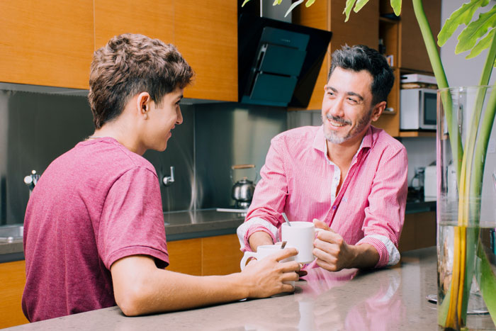 A dad and his son share a casual moment, chatting about family, adoption, and their relationship. A dad and his son share a casual moment, chatting about family, adoption, and their relationship.