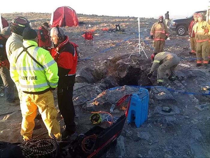 Cave rescuers and firefighters gathered around the entrance of Nutty Putty Cave, preparing for a rescue operation.