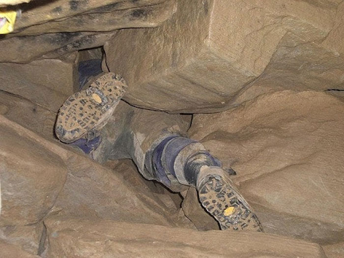 The legs and boots of the man trapped headfirst in Nutty Putty Cave, showing the difficult rescue conditions.