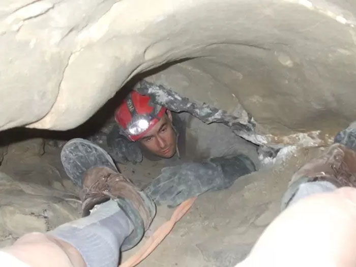 The cave rescuer carefully maneuvers through the tight space in Nutty Putty Cave during the rescue effort.