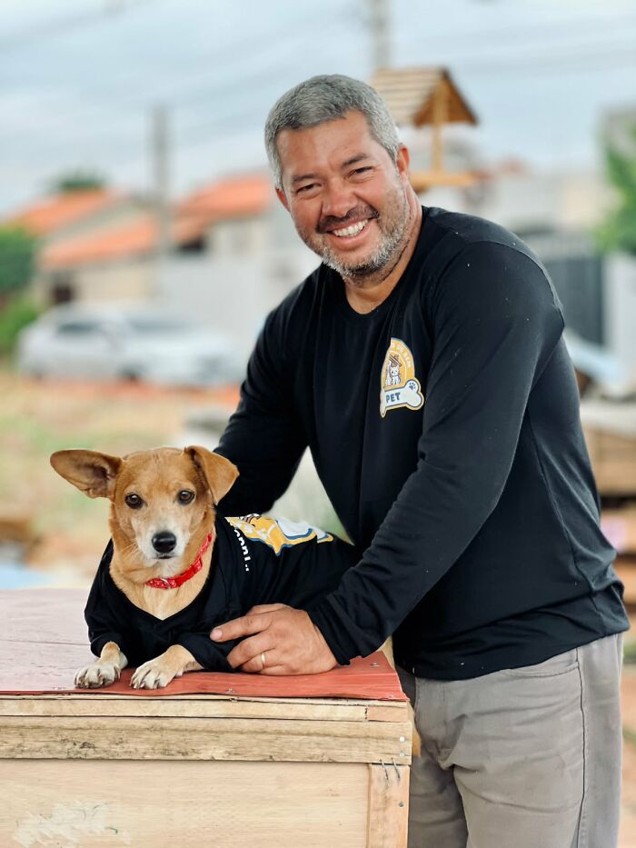 A truck driver from Brazil with a dog, both wearing black shirts, symbolizing animal shelters for animals in need. A truck driver from Brazil with a dog, both wearing black shirts, symbolizing animal shelters for animals in need.