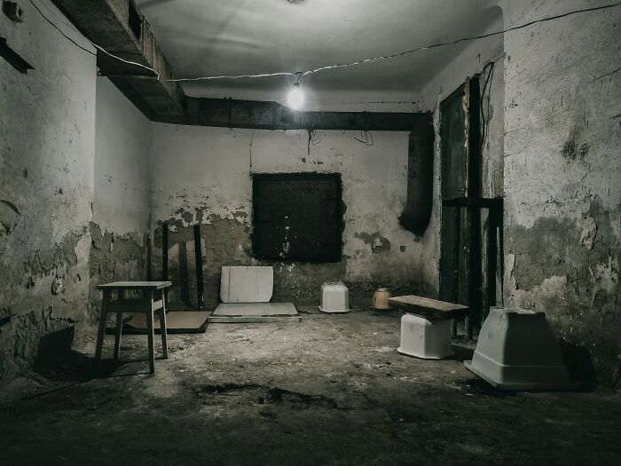 A dark, decrepit room with peeling paint, hinting at untold World War II veterans' extraordinary stories.