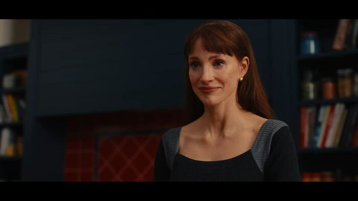 A woman with red hair and bangs smiles slightly indoors, from The Odyssey trailer. A woman with red hair and bangs smiles slightly indoors, from The Odyssey trailer.