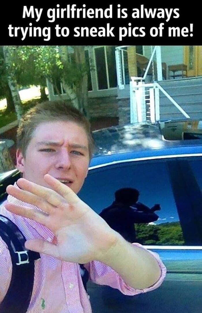 A man trying to take a selfie while claiming his girlfriend is sneaking pictures, busted for lying by a reflection.
