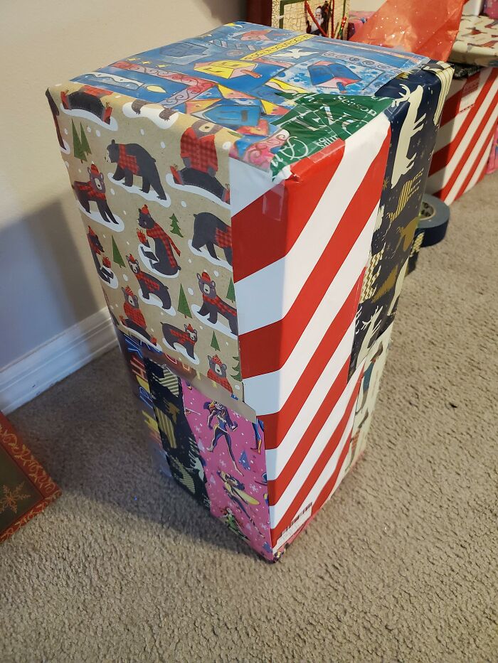 A tall, rectangular present wrapped in various papers, stories about MILs.