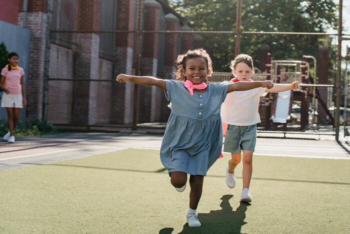 Two young children playing outside, dressed as superheroes, stories about MILs.