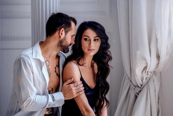 A man with tattoos on his arm looking at a woman, highlighting the need to check your lock screen to avoid pocket dial stories.