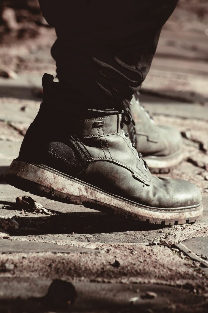 A person wearing dirty work boots, illustrating the practical, sometimes messy, problems HR handles.