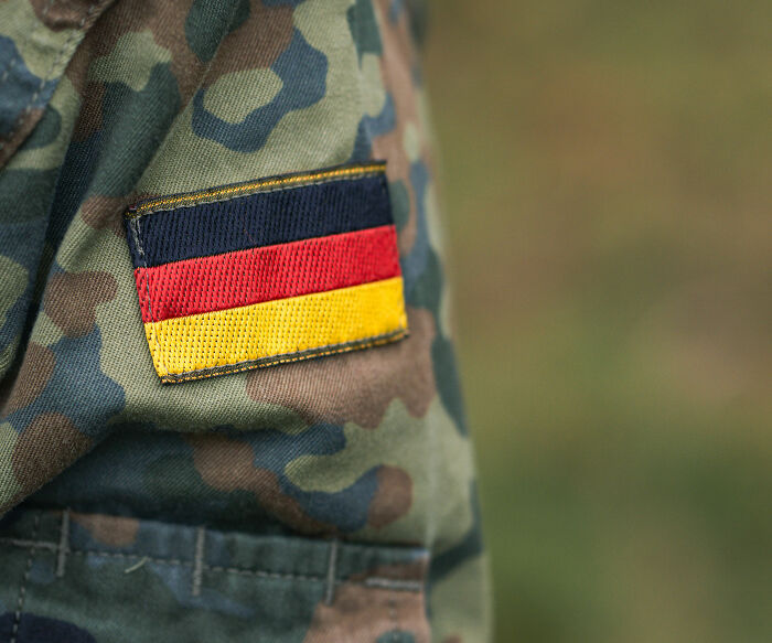 A close-up of a German flag patch on a camouflage uniform, symbolizing World War II veterans extraordinary stories.
