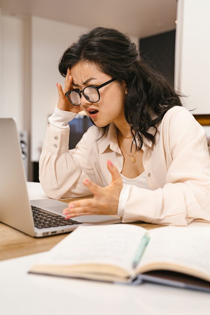A woman looking frustrated at a laptop, illustrating common reactions to entitled friends.